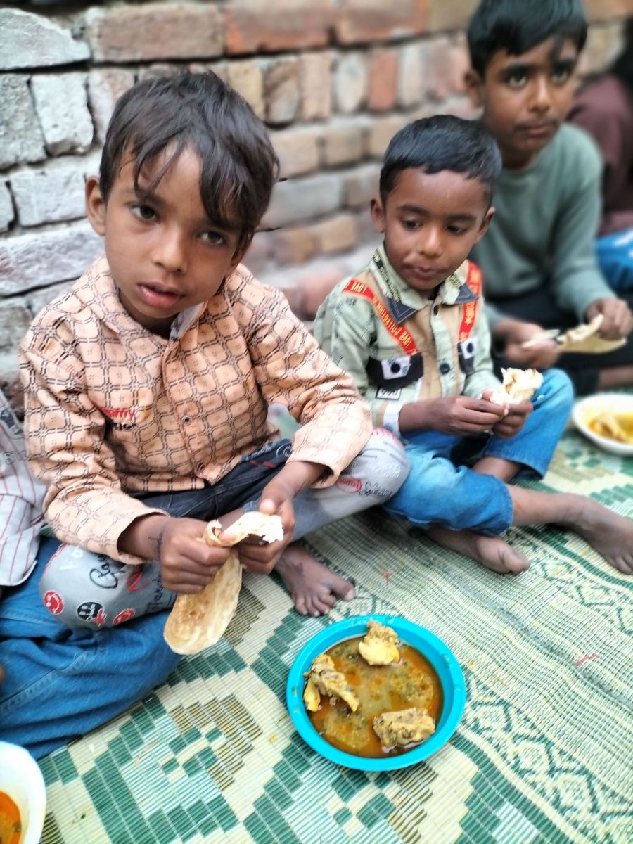 Two little boys eating a chicken meal