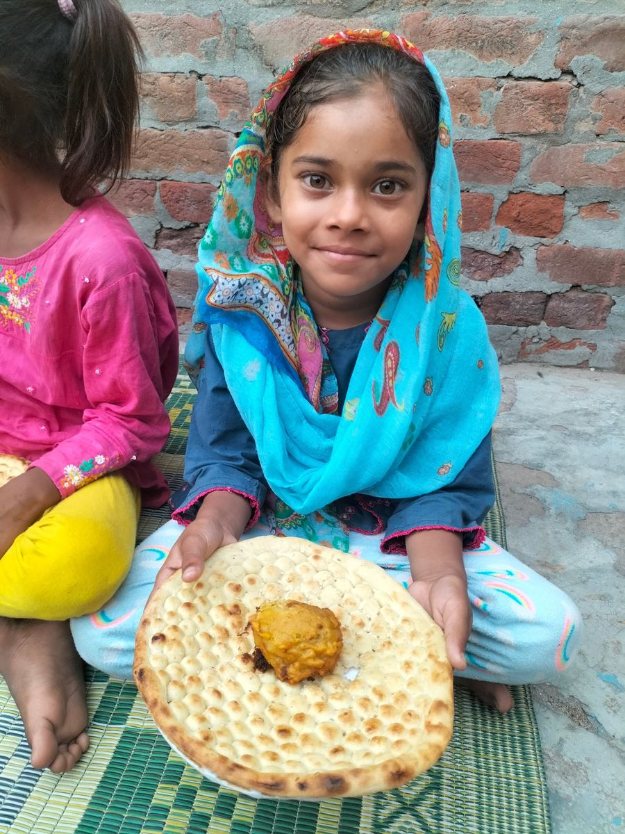 A smiling girl holding her bread and meal