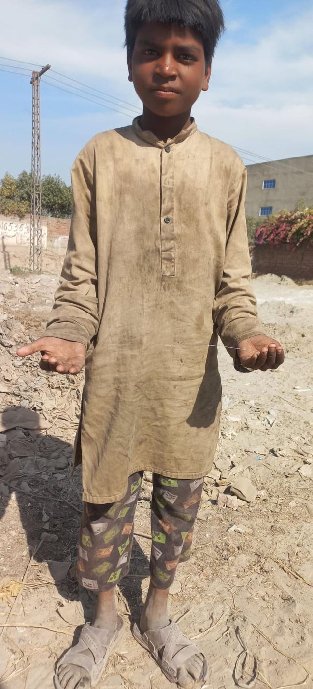 A boy in dirty clothes holding out his hands