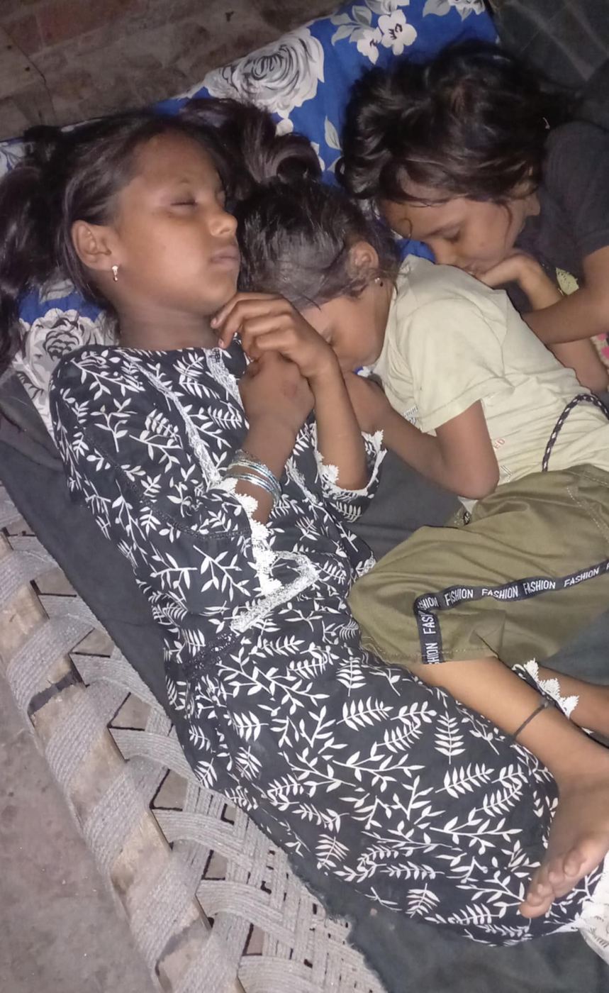 Three little girls sleeping squeezed into one small bed