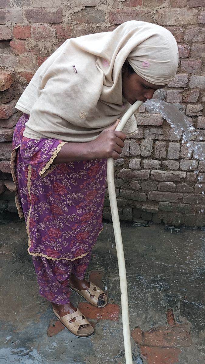 A woman drinking clean water from the well